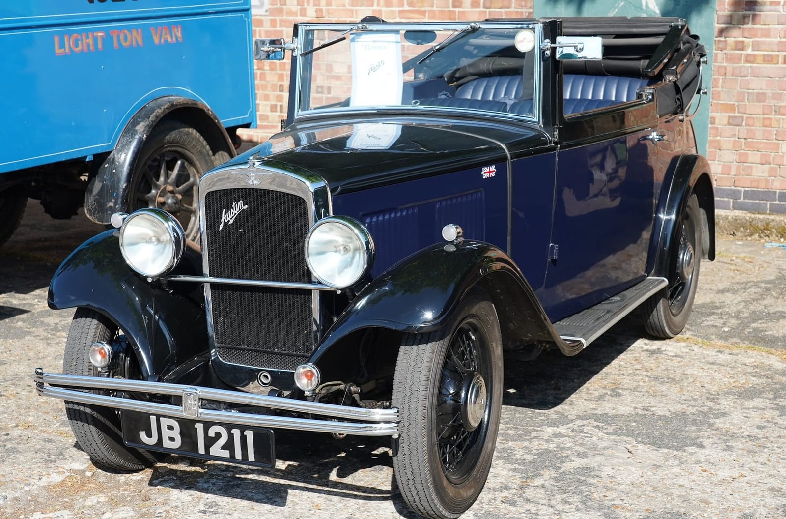 A dark blue 1932 Austin Ten-Four drophead coupe with its hood folded, UK registration JB 1211