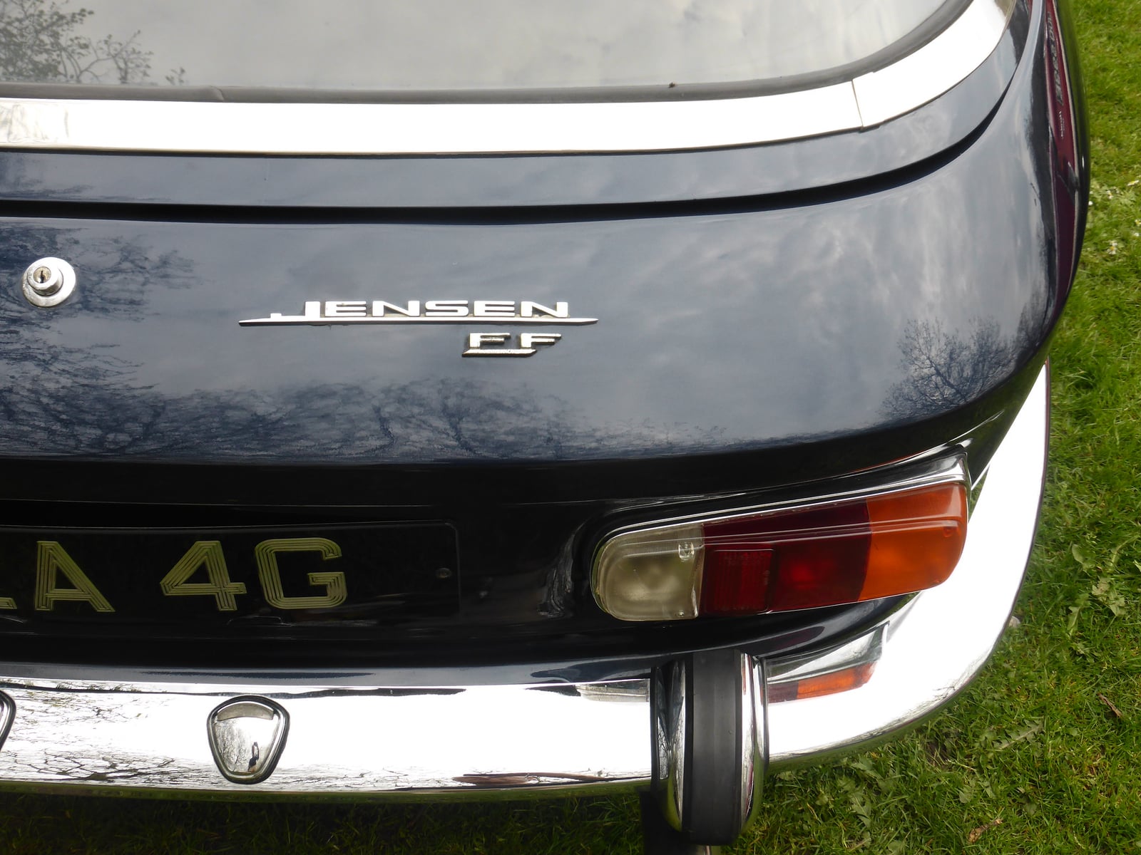Close-up of the Jensen FF badge on the rear of a dark blue car