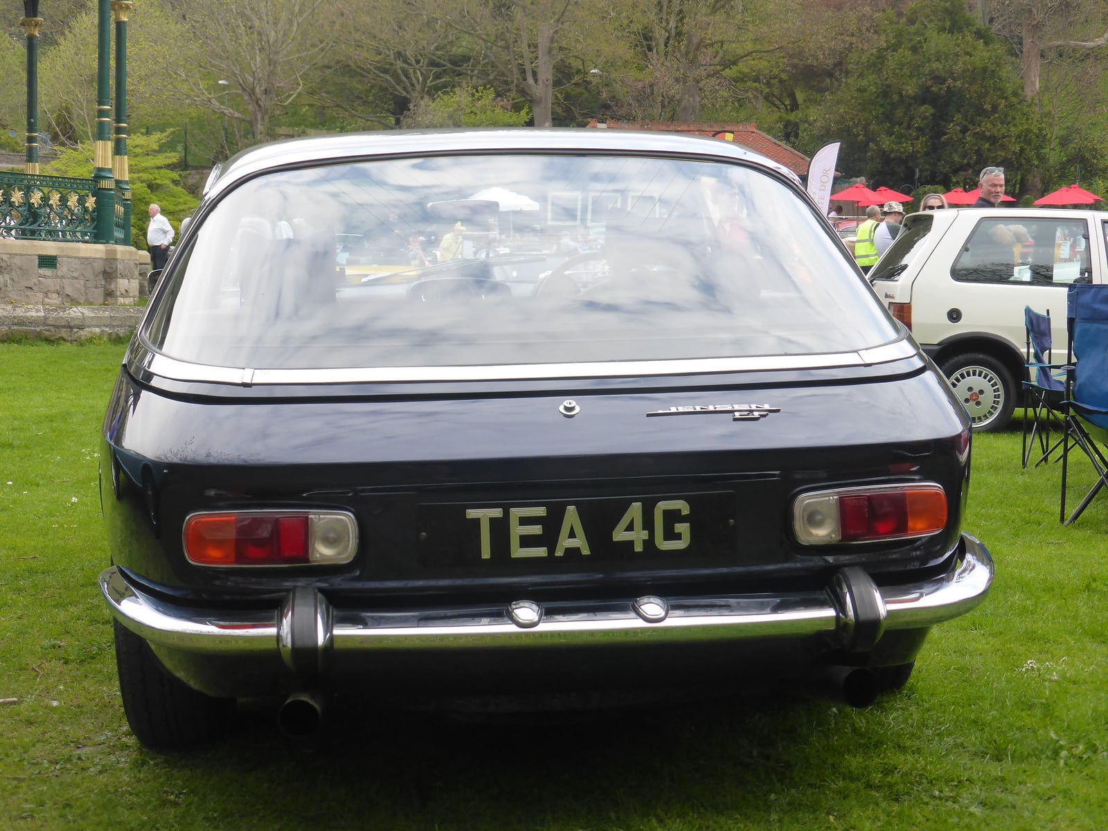 The rear of a dark blue Jensen FF, showing the wraparound glass tailgate