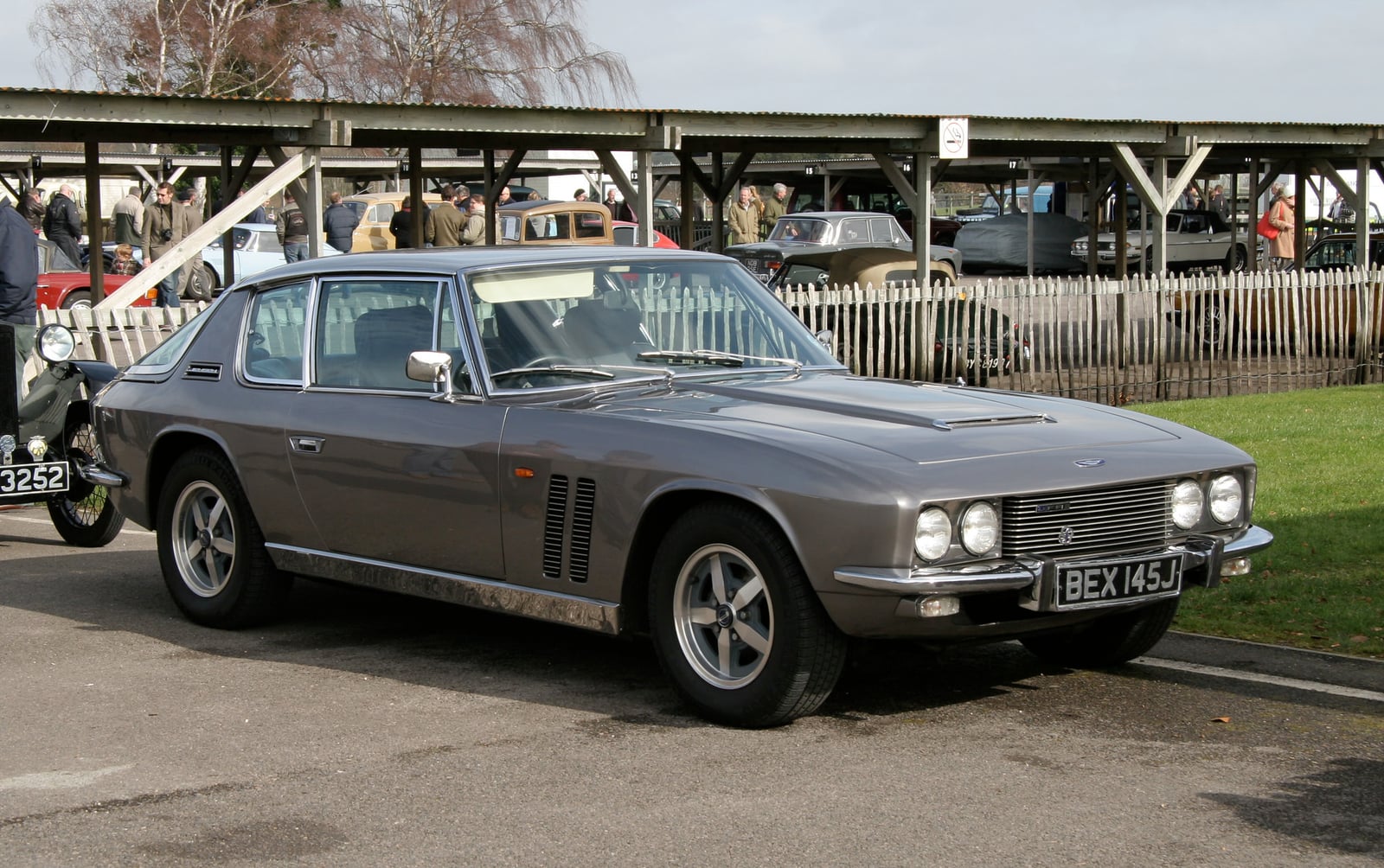 A grey Jensen FF Series 2 under cover at a show, front three-quarter view