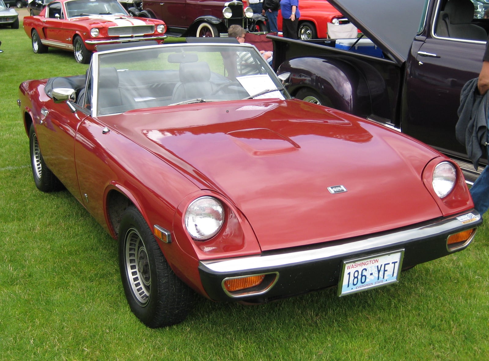 A red Jensen-Healey roadster at a show, front three-quarter view