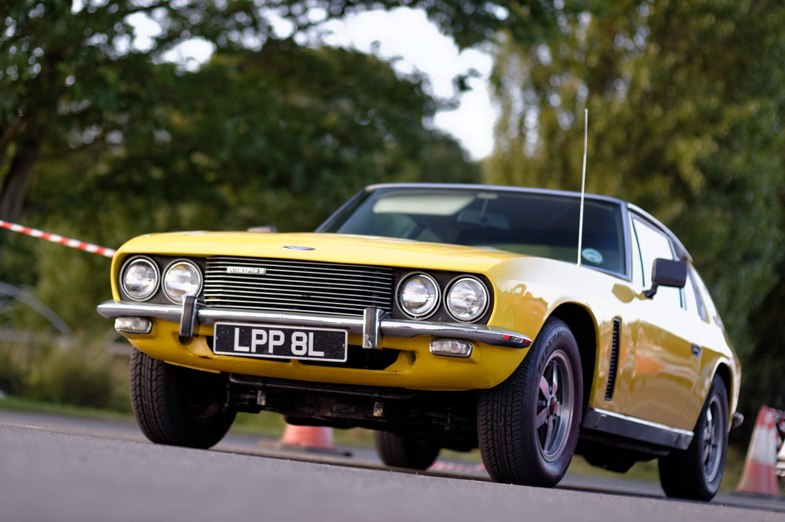A gold Jensen Interceptor on grass, front three-quarter view