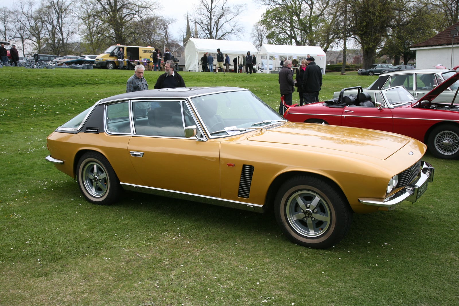 A gold Jensen Interceptor at a show, front three-quarter view