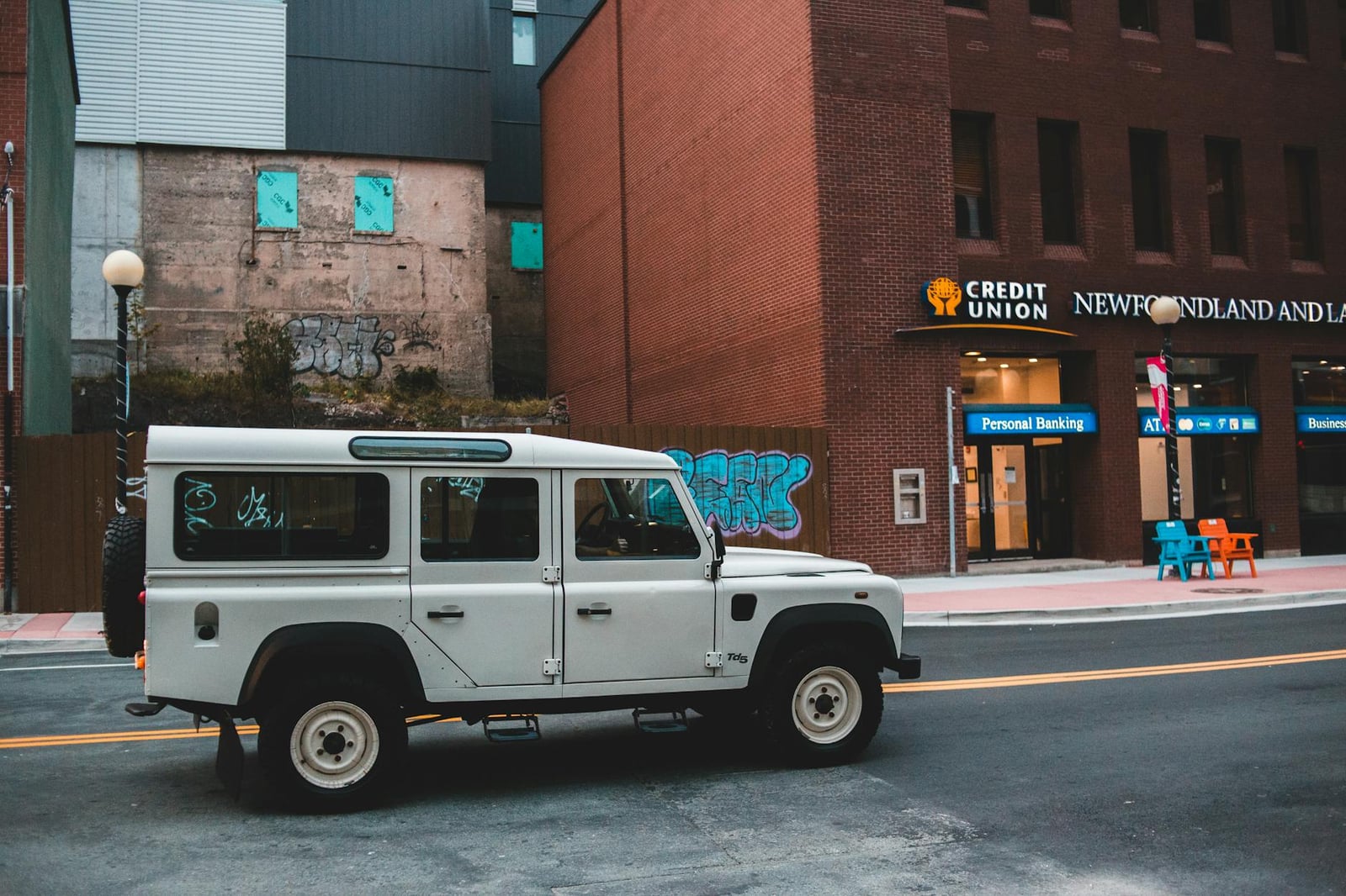 A white Land Rover Defender 110 Td5 parked on a city street