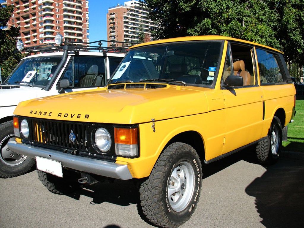 A gold two-door Range Rover Classic parked on an urban street