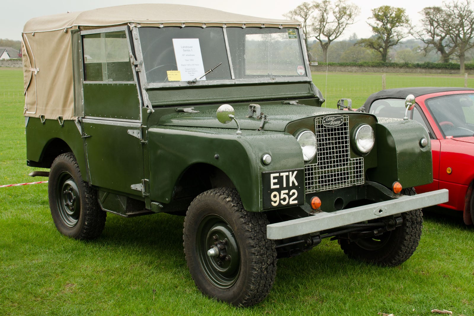 An early green 80-inch Land Rover Series I in a field