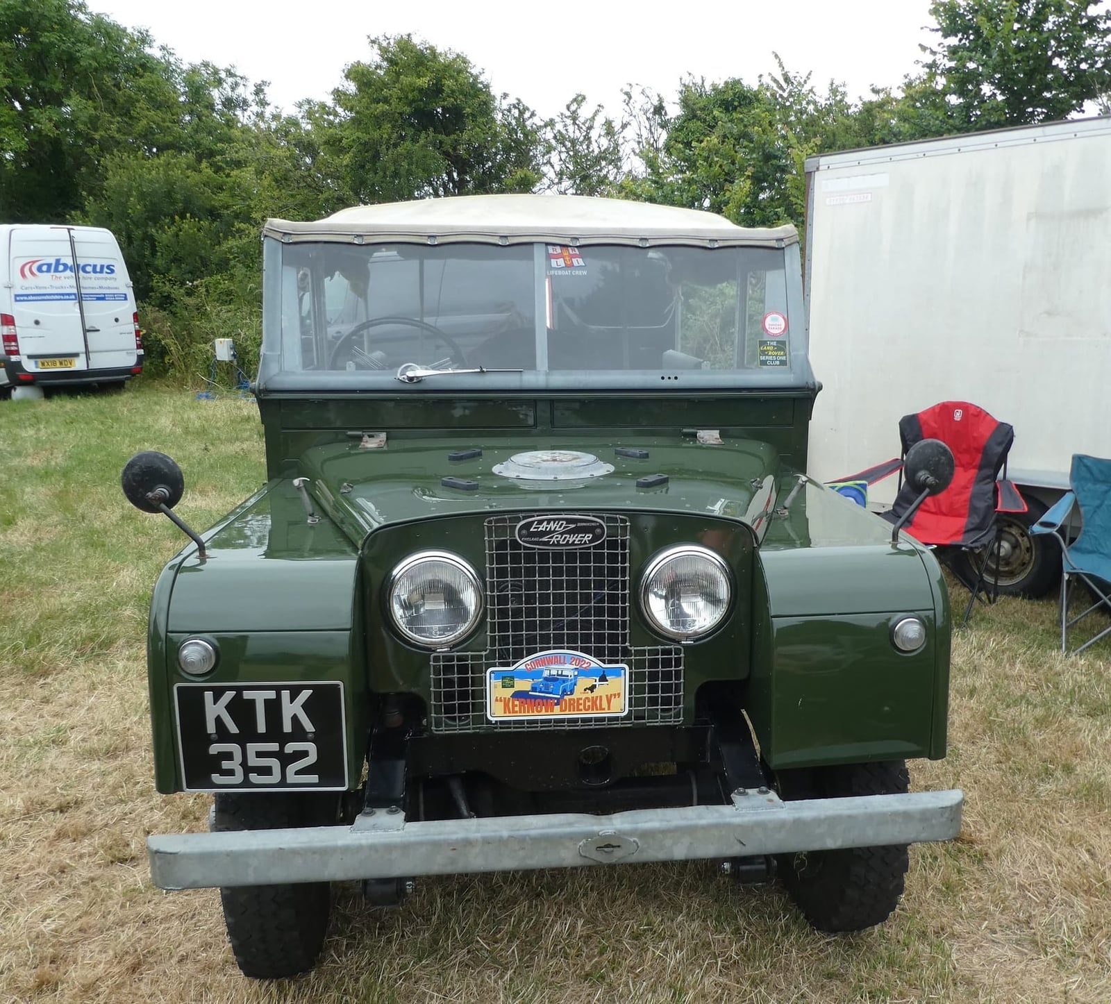 A green 1957 Land Rover Series I 88 with a canvas tilt and a UK registration at a show