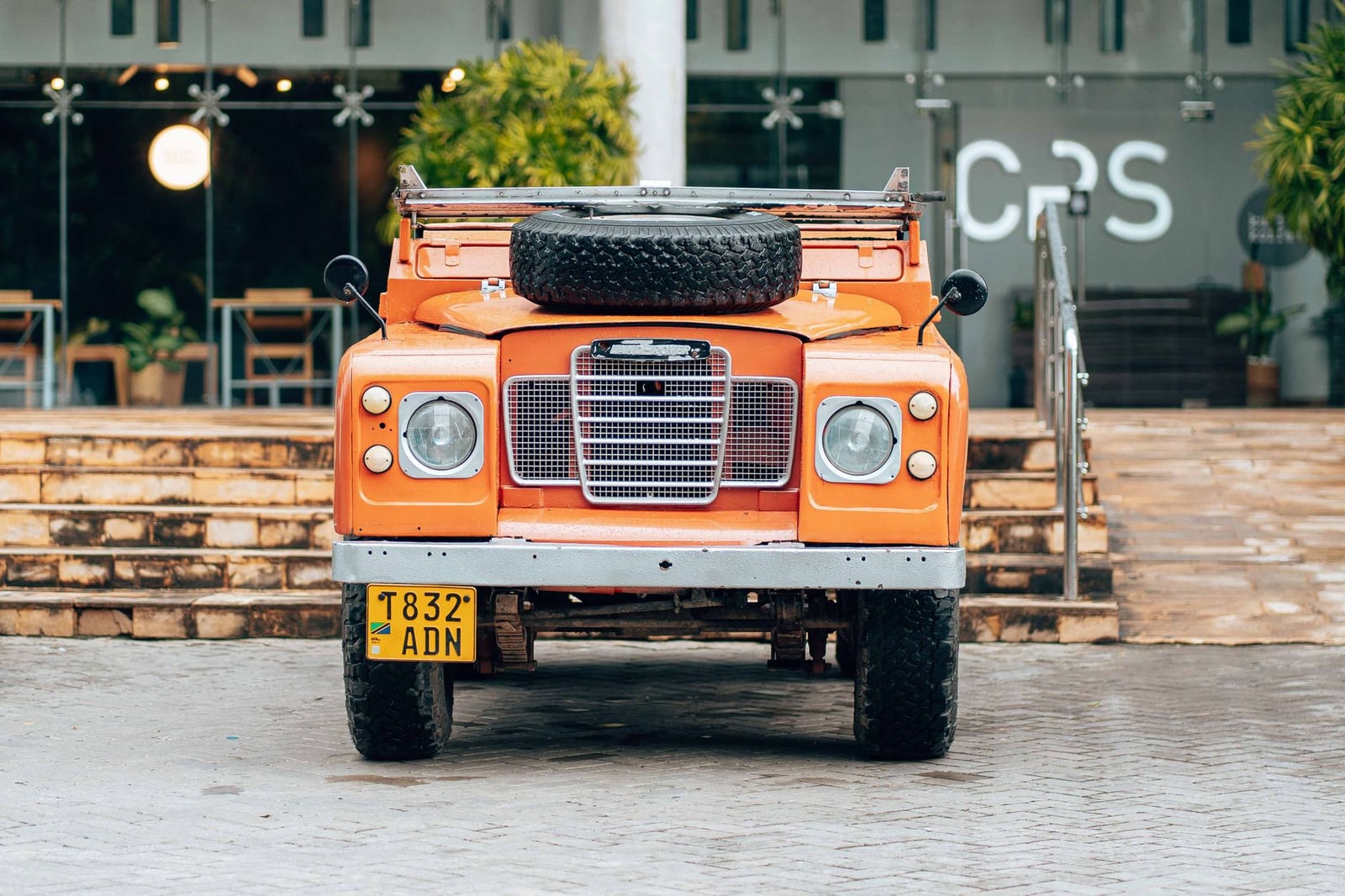 Head-on view of an orange Land Rover Series III with a UK number plate