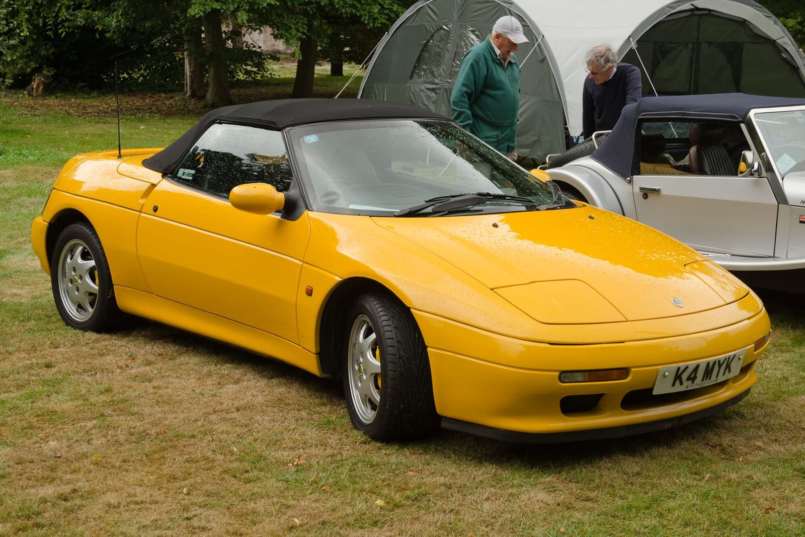 A yellow 1992 Lotus Elan M100 Turbo SE with a UK registration on a show field