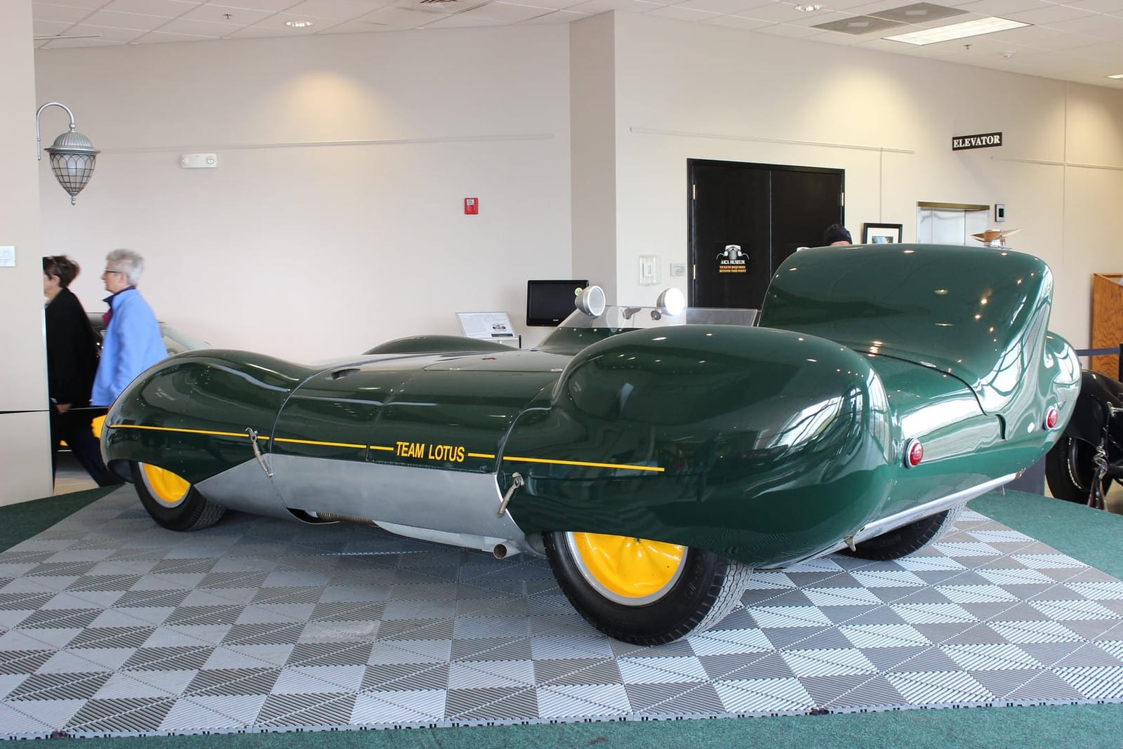 A green and yellow Team Lotus liveried Lotus Eleven Series 2 Le Mans displayed indoors