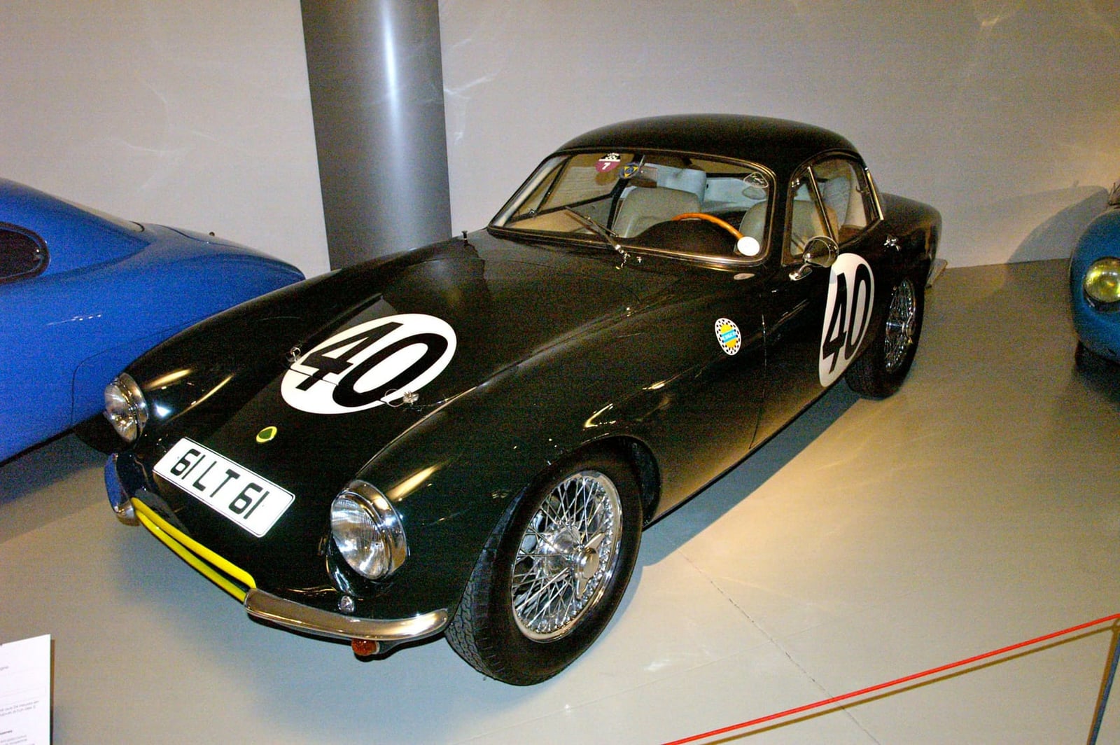 A black Lotus Elite with racing number 40 and wire wheels displayed in a museum, registration BLT 61