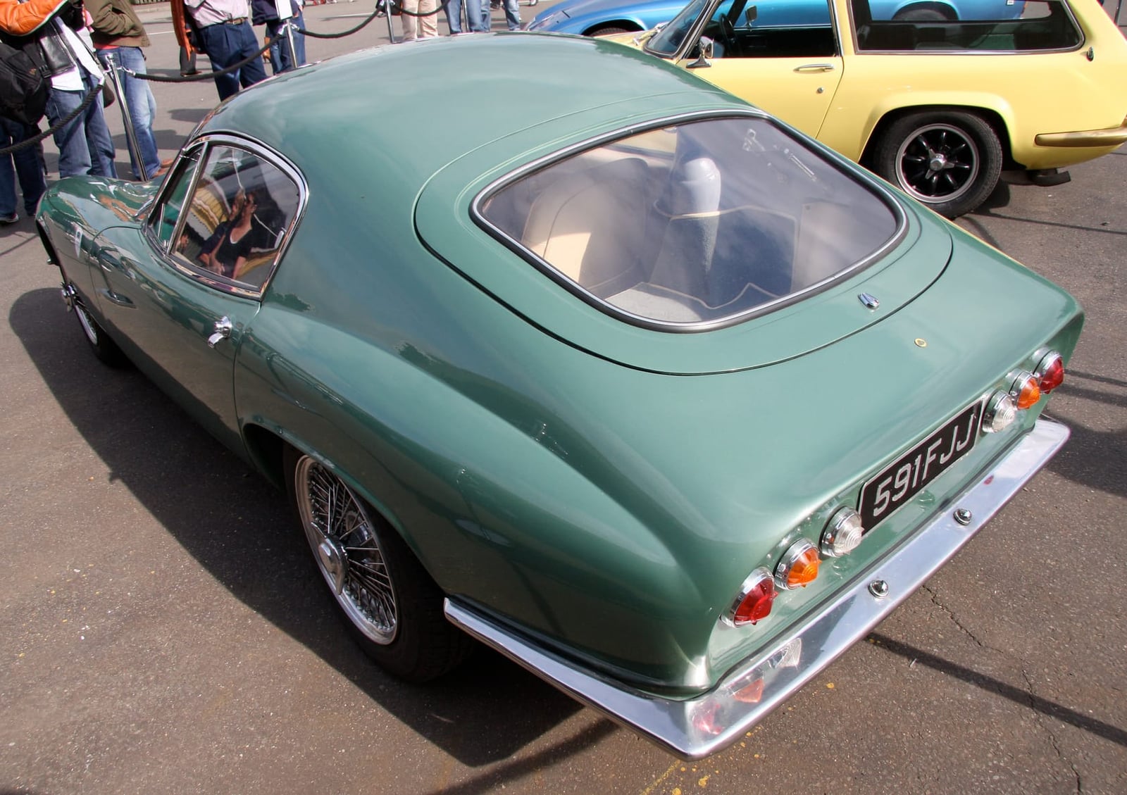 The rear of a green Lotus Elite on wire wheels, showing the tail lights and boot