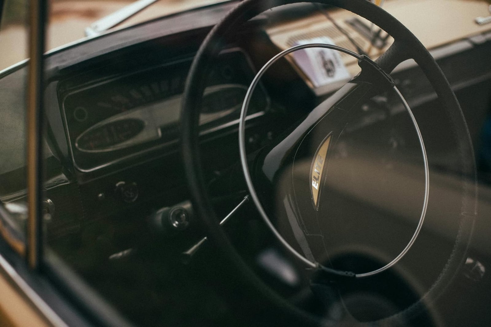The wood-rimmed steering wheel and dashboard of a Lotus Elite in low light