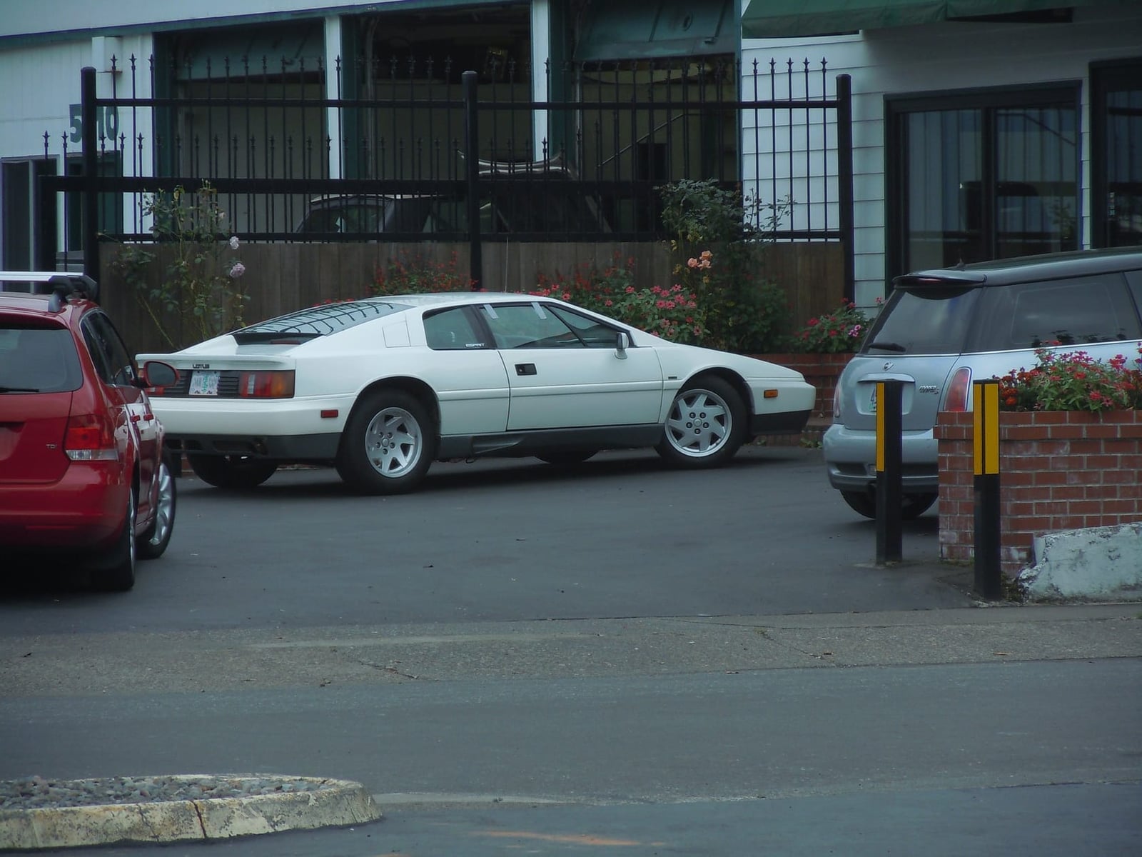 A white Peter Stevens-era Lotus Esprit Turbo parked on a street