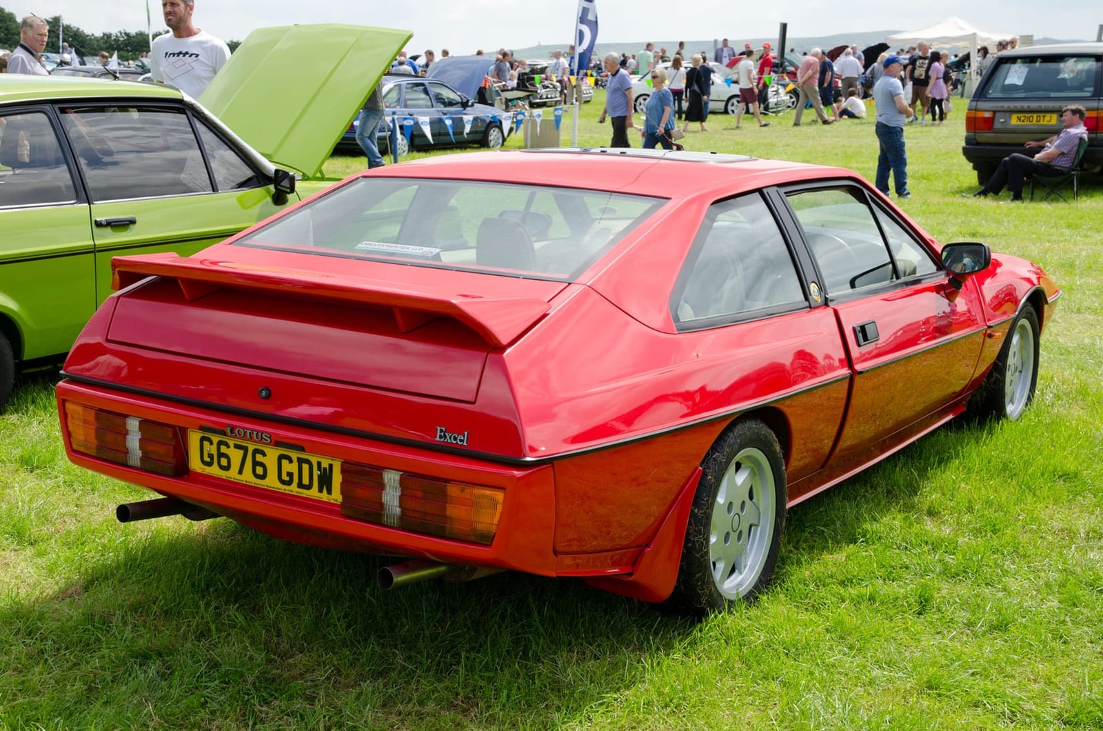 The rear of a red 1989 Lotus Excel SE showing the spoiler and tail lights, UK registration G676 GDW