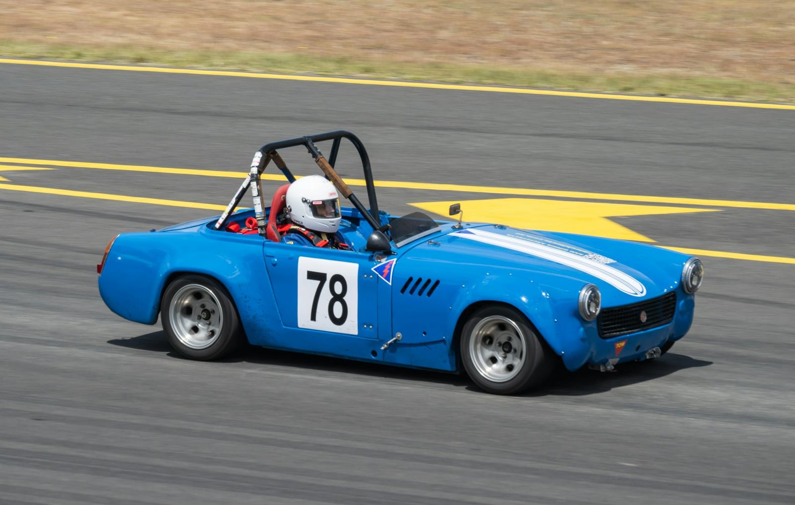 A blue MG Midget racing car on a circuit