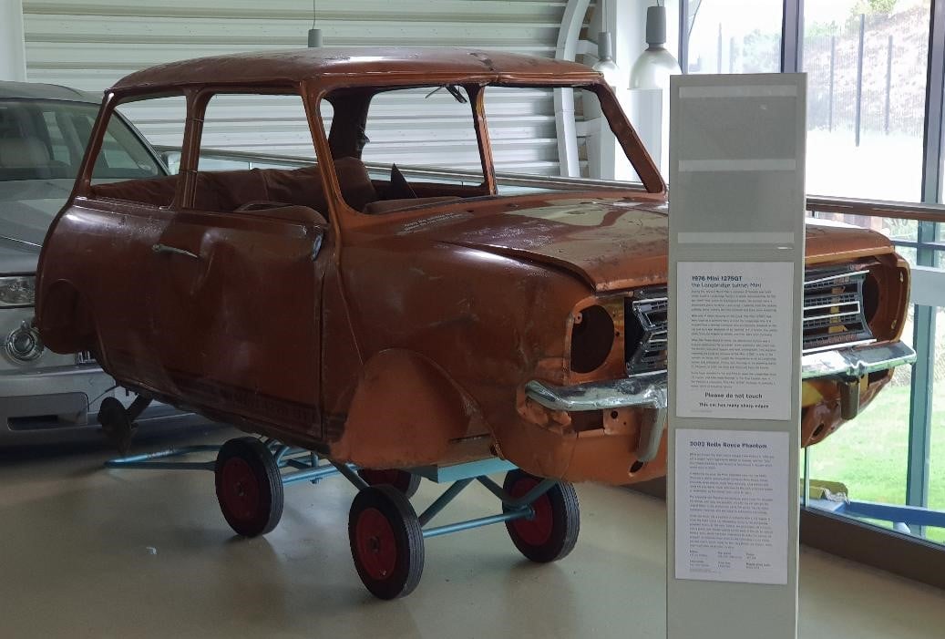 A Mini stripped to a bare shell under restoration, on a display stand