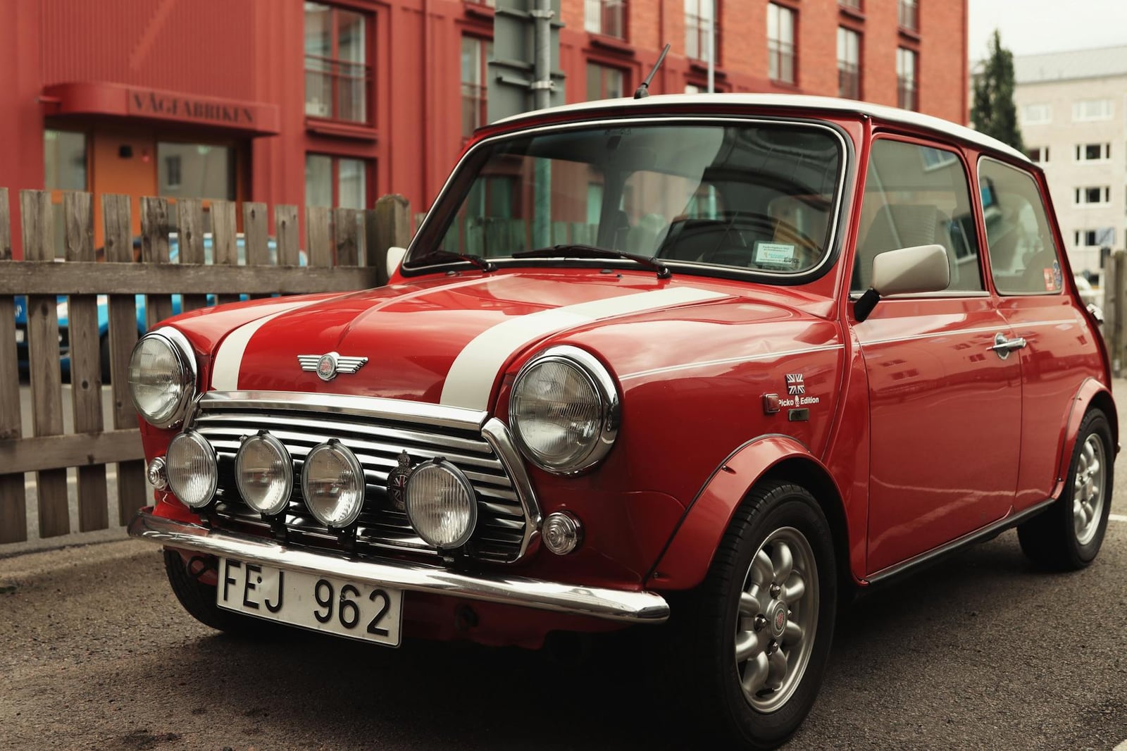 A red Mini Cooper with a white roof, front three-quarter view