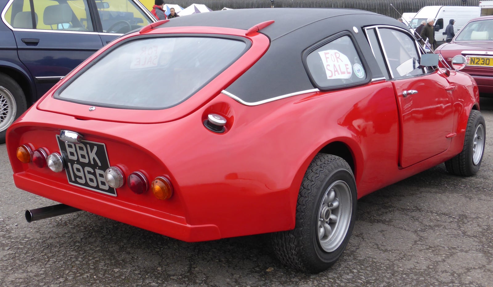 A red 1964 Mini Marcos photographed from the rear, showing the cut-off tail