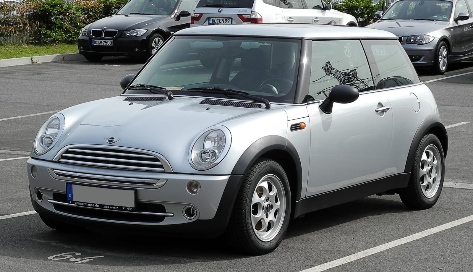 A silver MINI One R50, the basic first-generation new MINI, parked in a city street