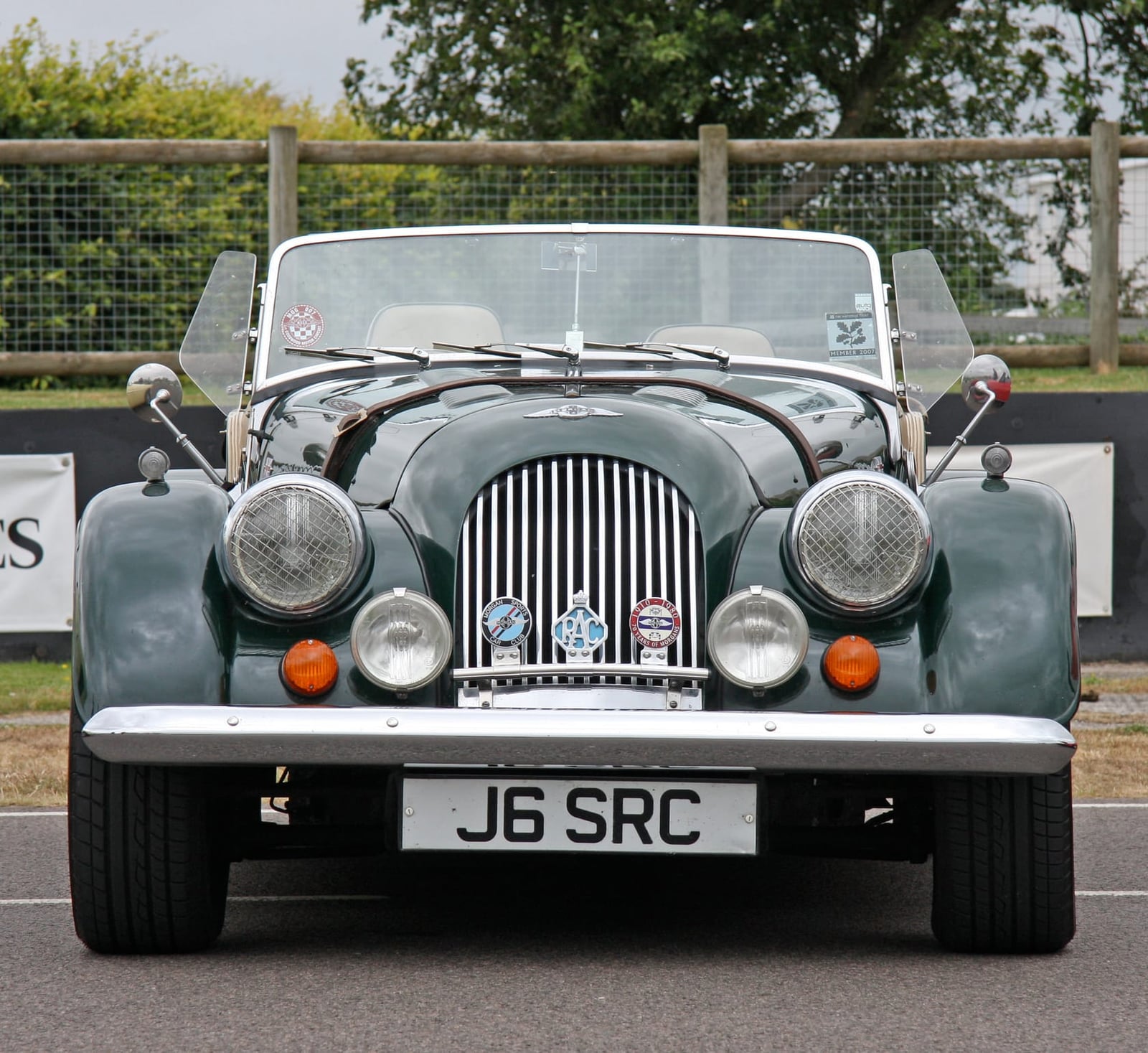 A dark green Morgan Plus 8 photographed head-on at a classic car event, UK registration J6 SRC