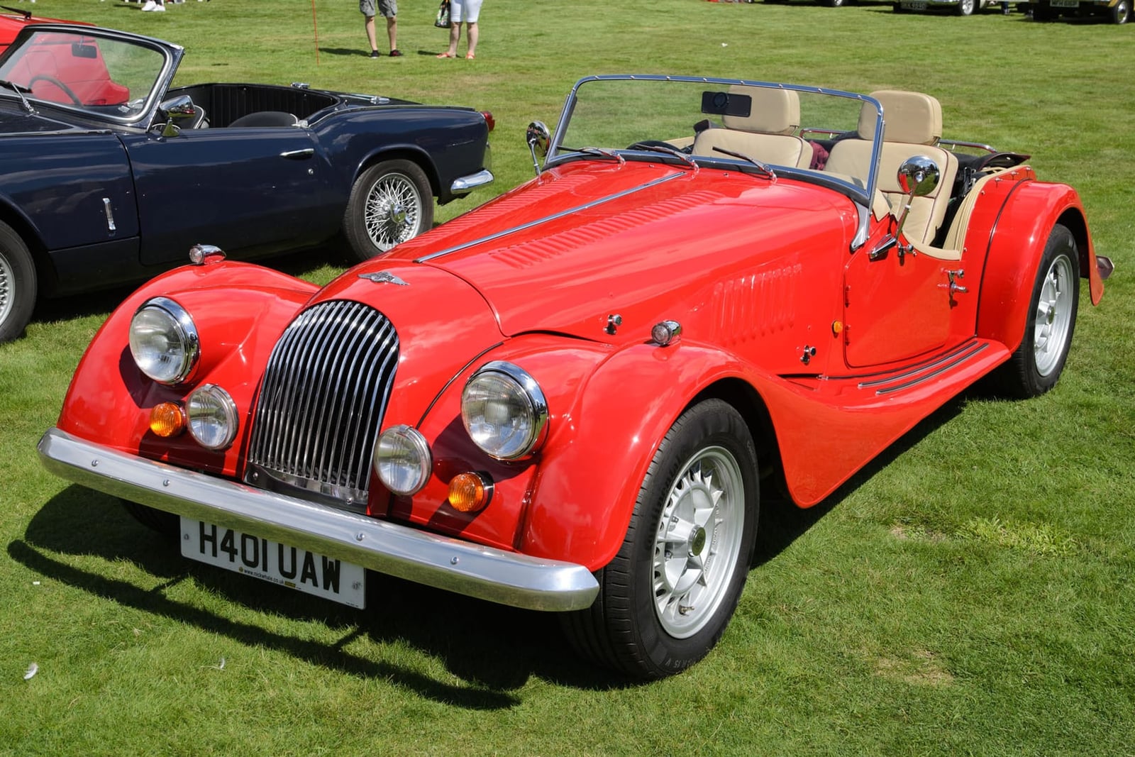 A red 1990 Morgan Plus 8 3.9 with UK registration H491 UAW, with a Triumph Spitfire behind