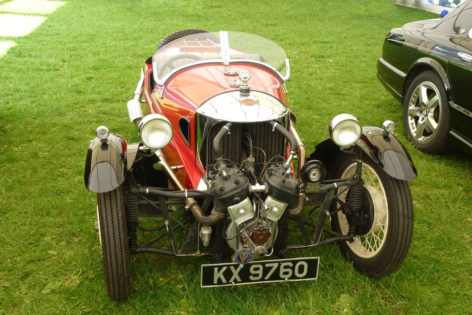 A red 1933 Morgan three-wheeler with exposed V-twin engine and UK registration KX 9760