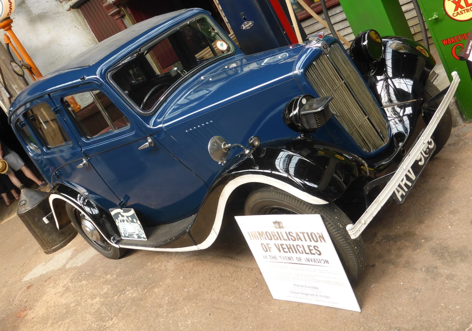 A dark blue 1938 Morris Eight Series II saloon displayed in a museum beside an information board