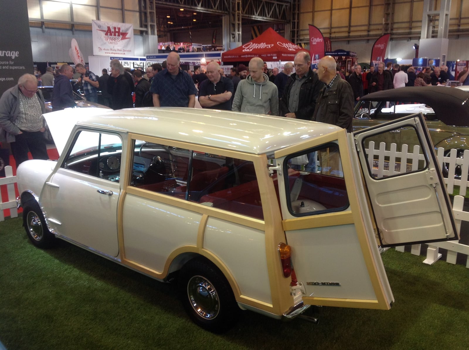 A cream woody Morris Mini Traveller with the rear doors open, side view