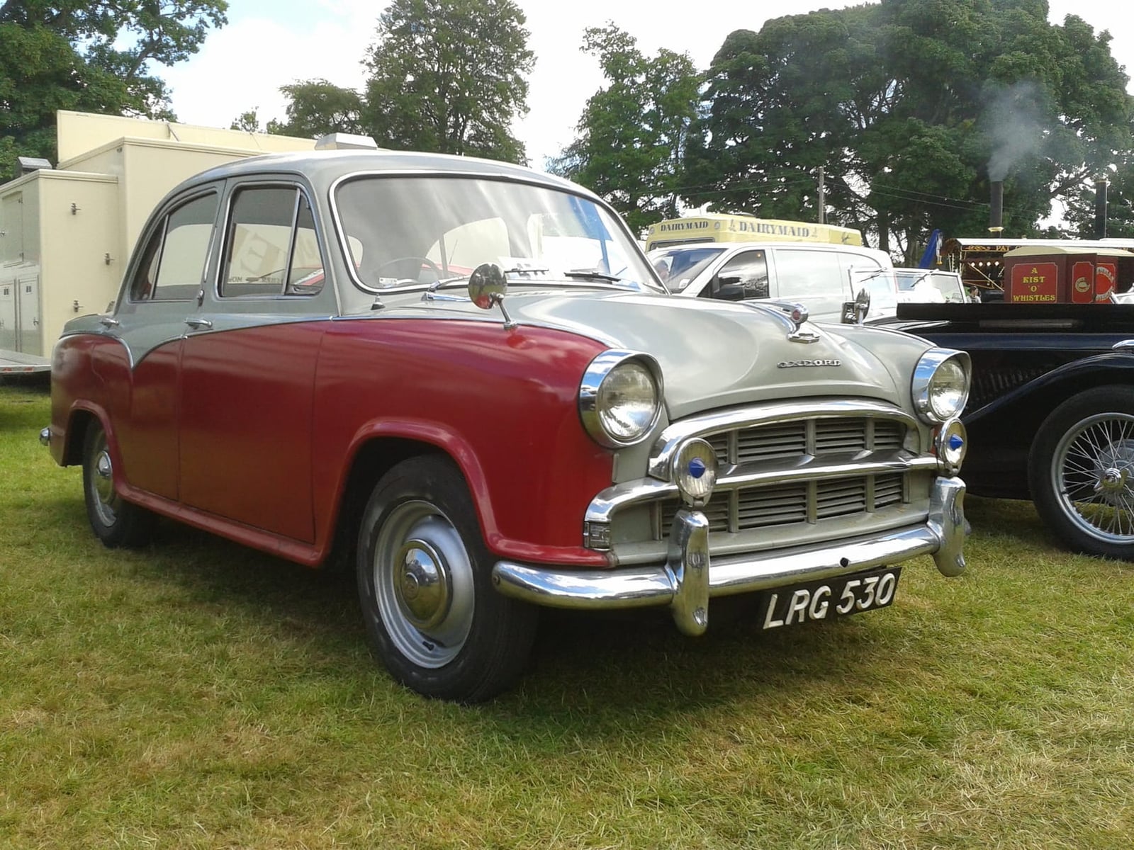 A red and grey two-tone Morris Oxford at a classic car show, front three-quarter view, UK registration LPG 53D