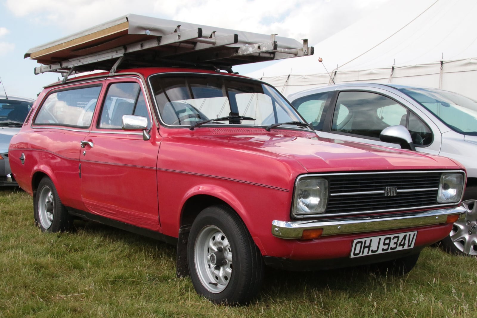 A red Ford Escort Mk2 estate at a show, front three-quarter view
