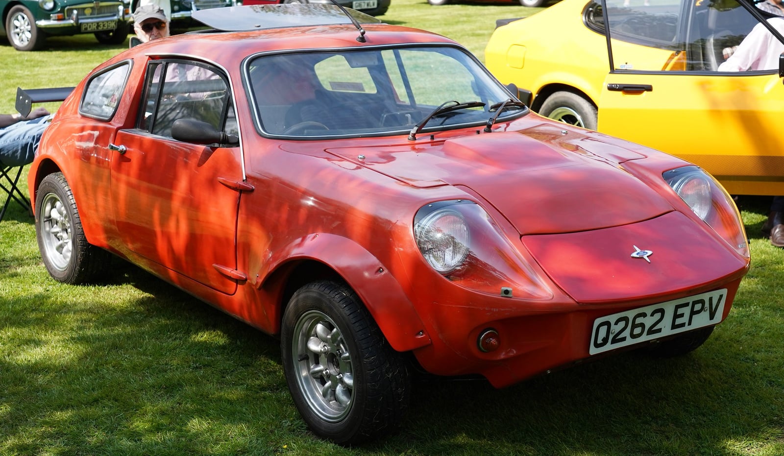 A faded red Mini Marcos coupe on a Q-plate registration, front three-quarter view