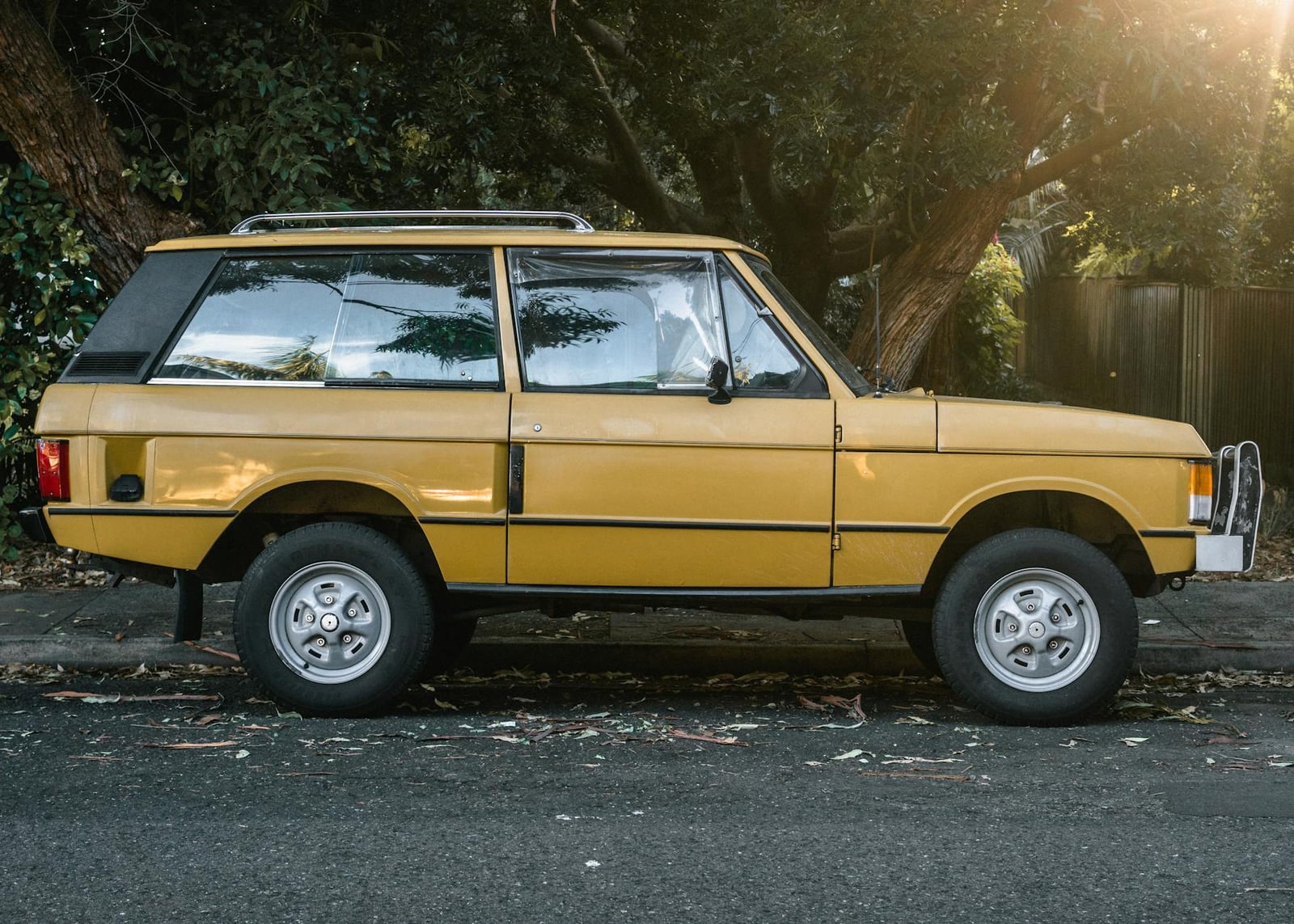 A gold two-door Range Rover Classic in clean side profile at sunset
