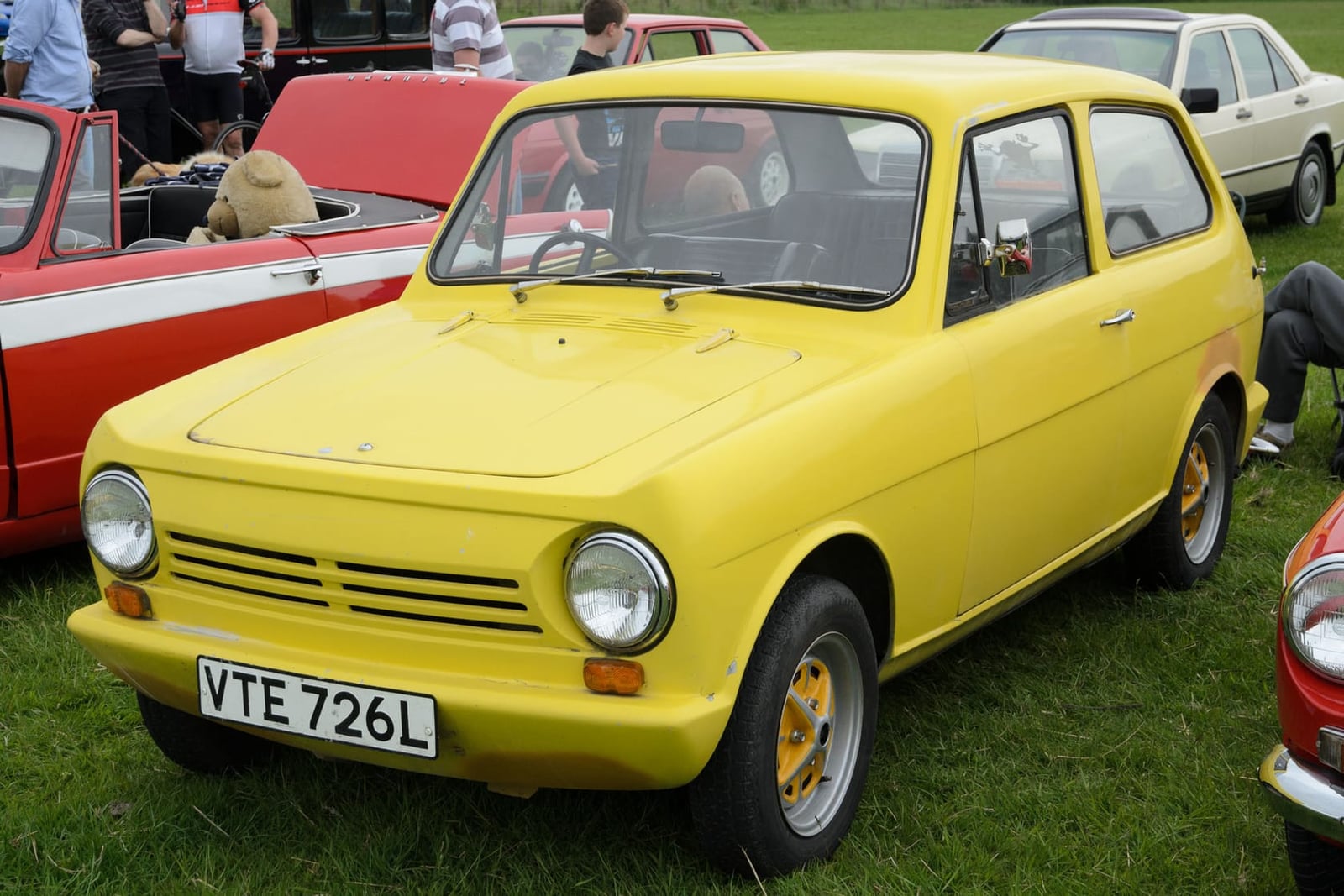 A yellow 1972 Reliant Rebel saloon at a show, front three-quarter view, UK registration VTE 726L