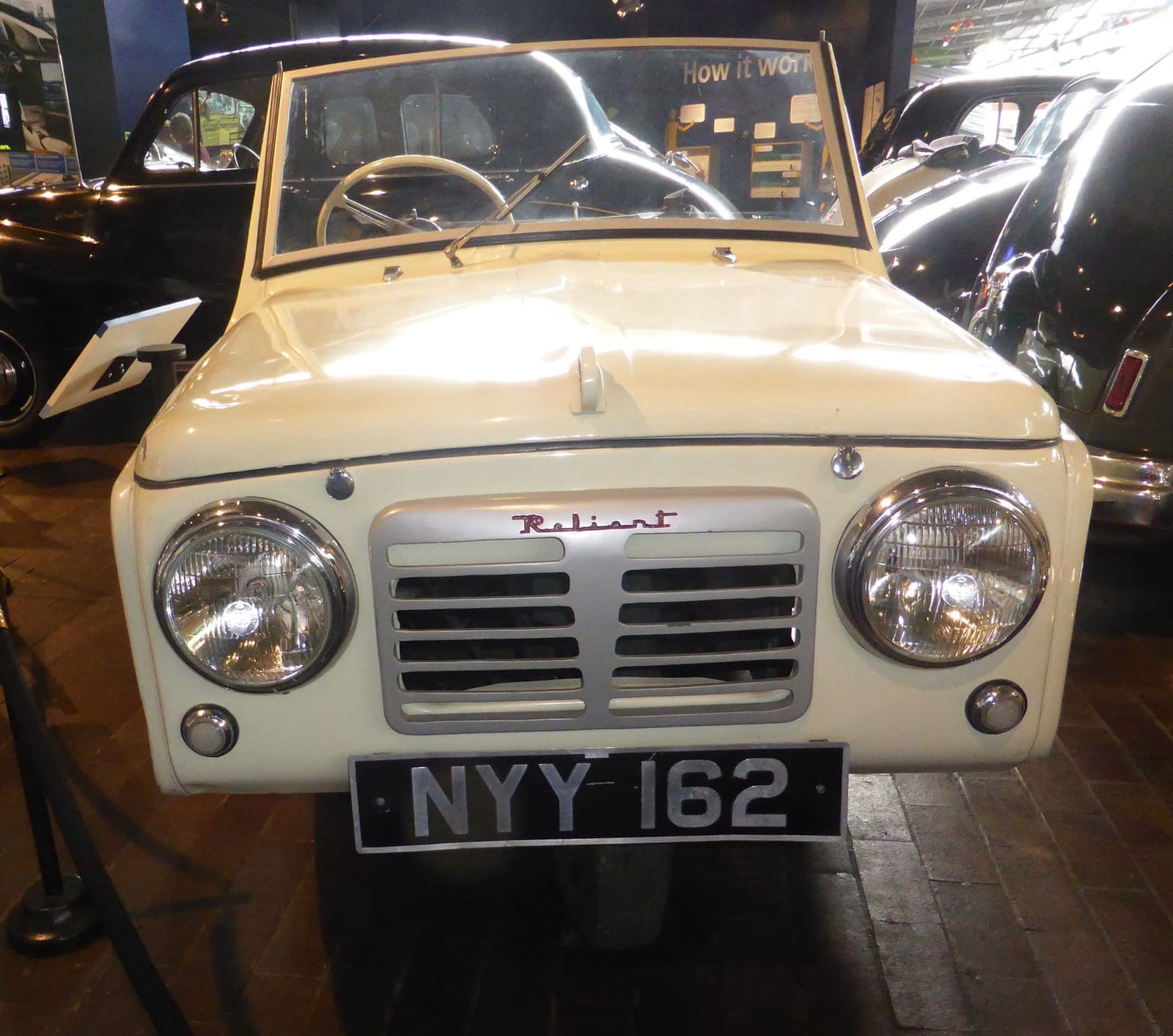 A cream 1954 Reliant Regal convertible on museum display, front view, UK registration NYY 162