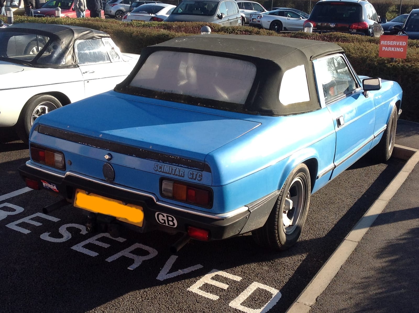 The rear three-quarter of a blue 1980 Reliant Scimitar GTC convertible with its hood raised