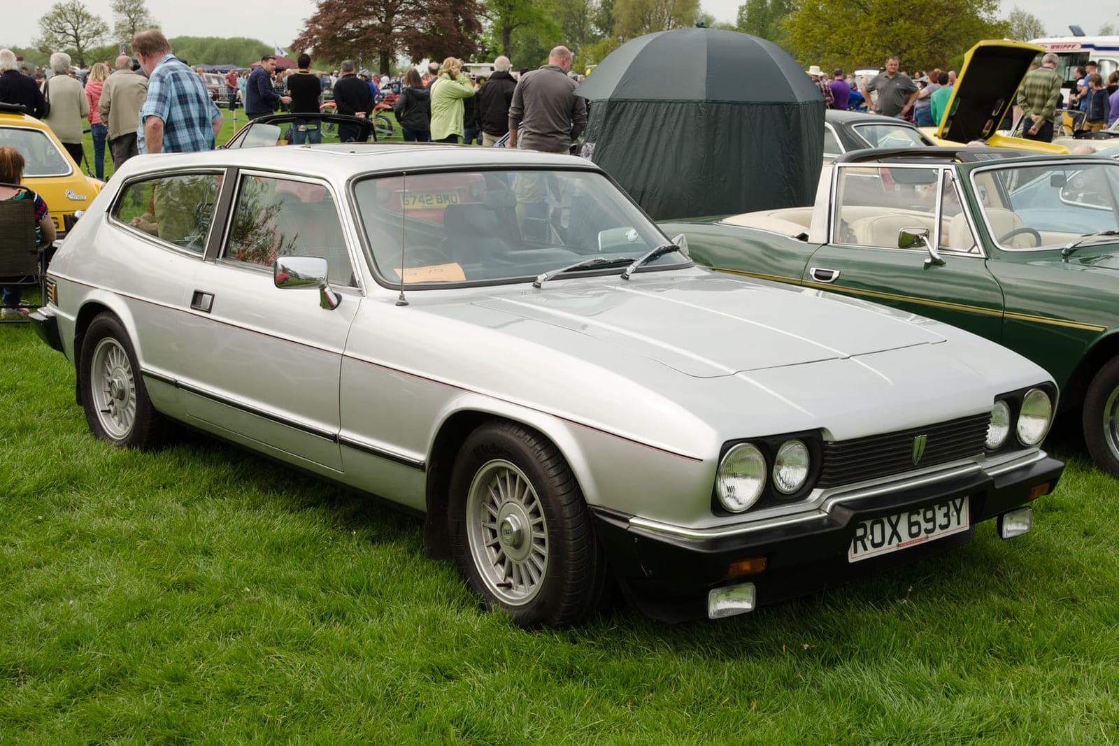 A silver 1983 Reliant Scimitar GTE SE6B on a showfield, front three-quarter view, UK registration ROX 693Y