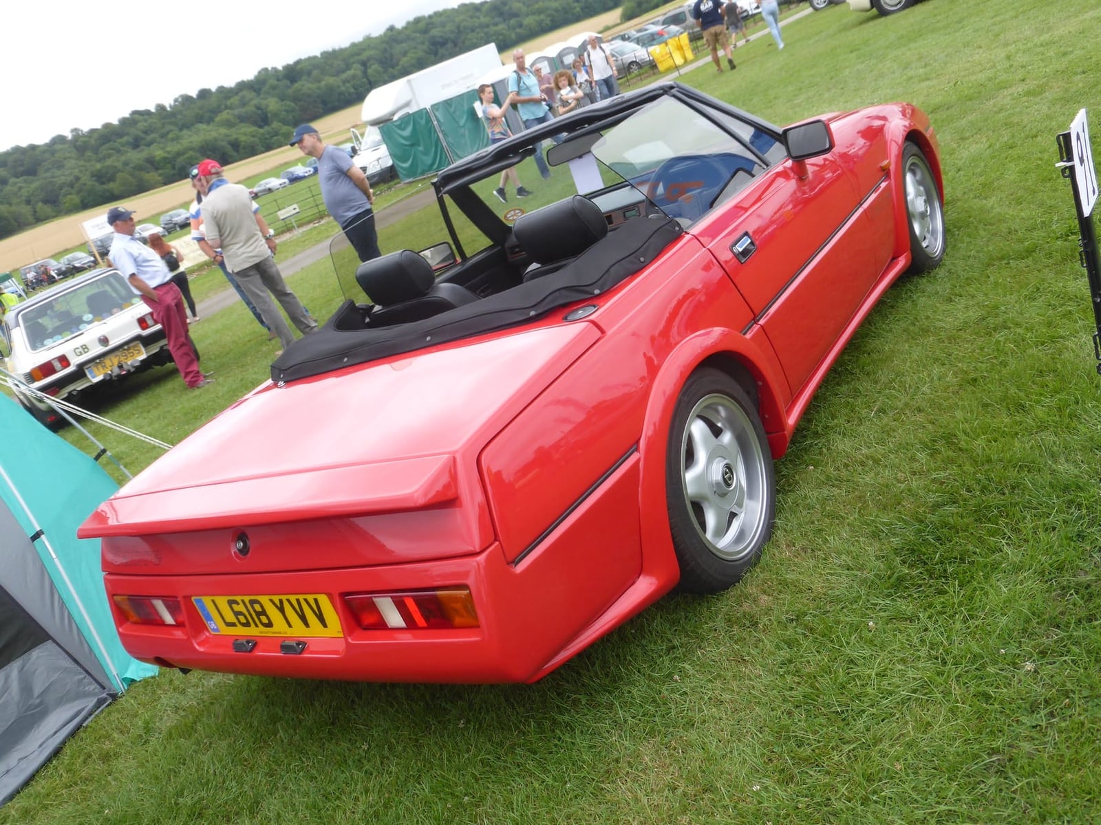 A red Reliant Scimitar Sabre 1.8 turbo on grass at a classic car show, rear three-quarter view, UK registration L618 YVV