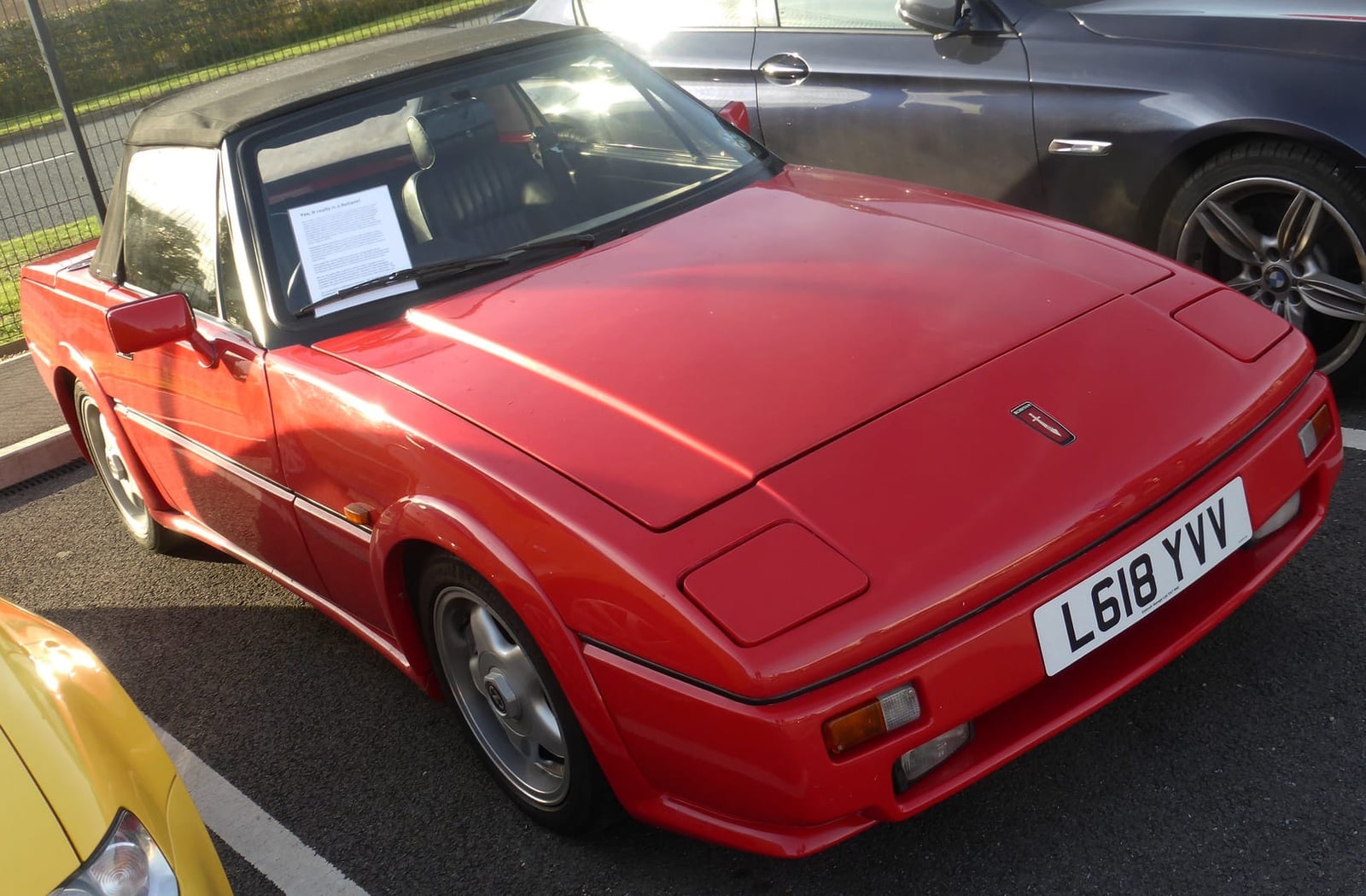 A red 1993 Reliant Scimitar Sabre parked on tarmac, front three-quarter view, UK registration L618 YVV
