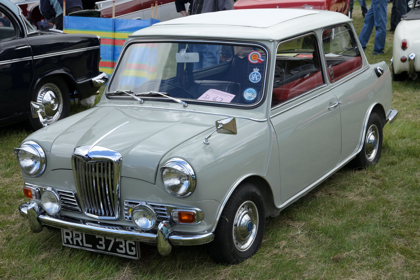 A fawn Riley Elf saloon at a show, front three-quarter view