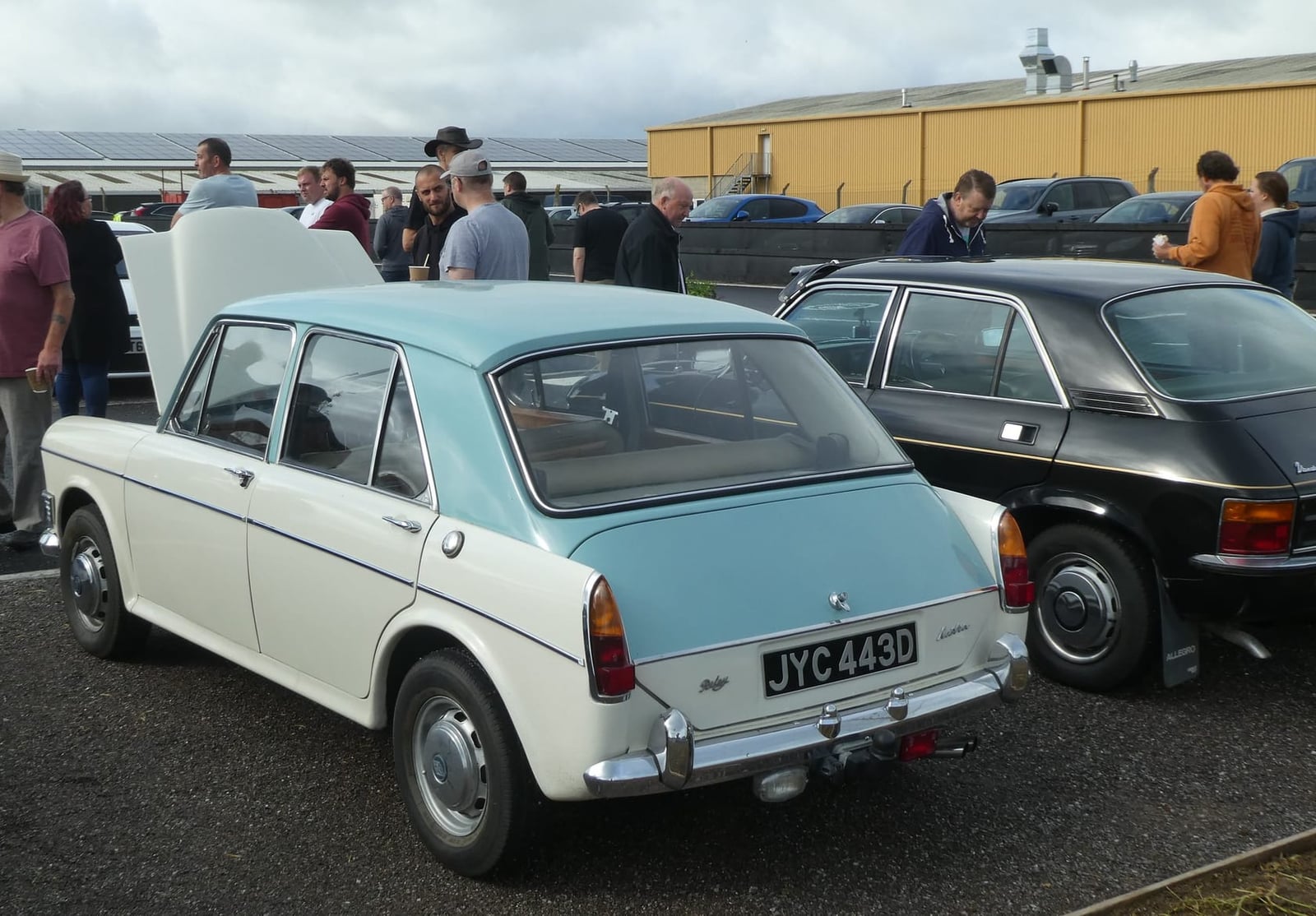 The rear three-quarter of a pale blue and white 1966 Riley Kestrel at a classic car show, UK registration JYG 443D
