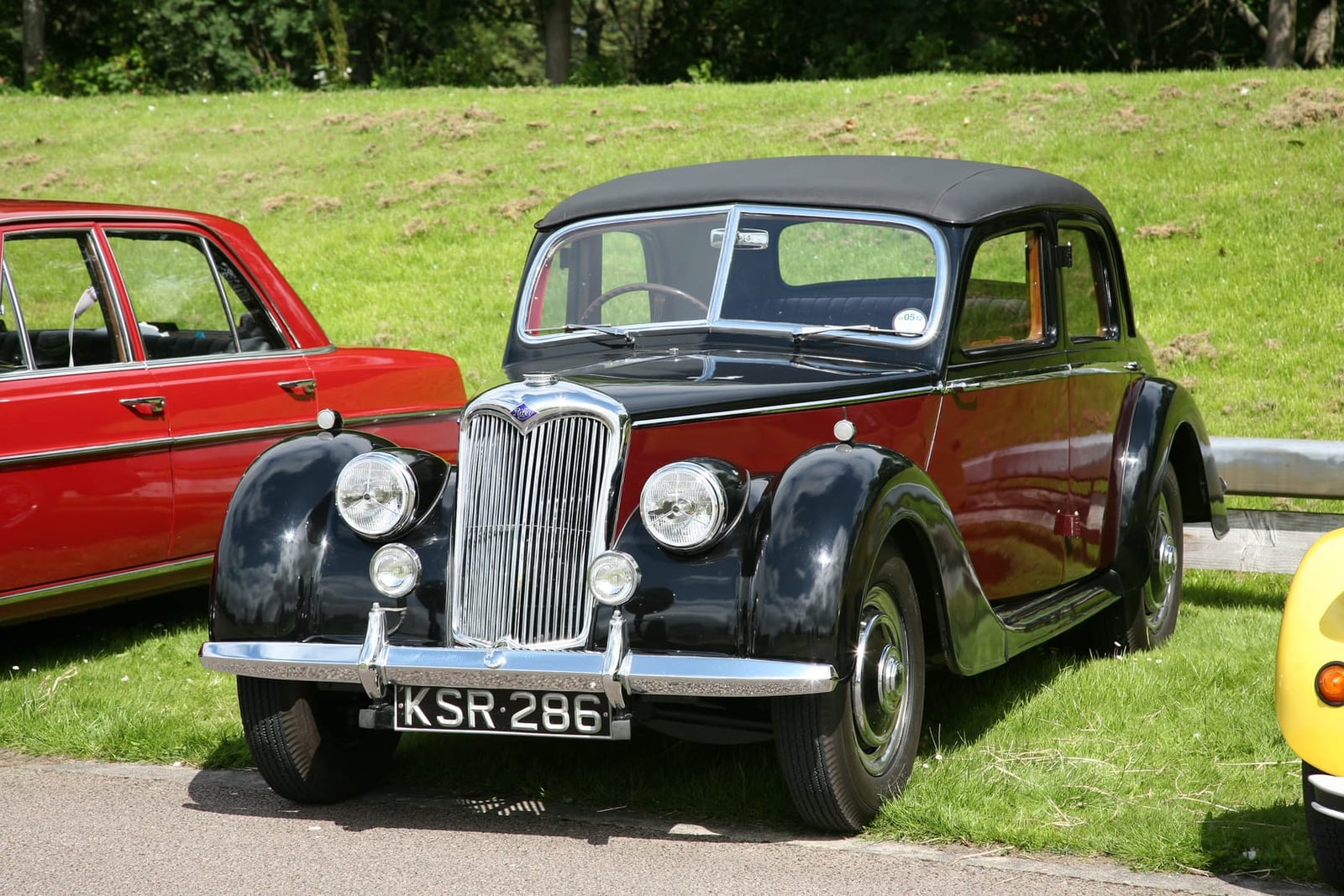 A dark Riley RM saloon on grass at a classic car show, front three-quarter view, UK registration KSR 286