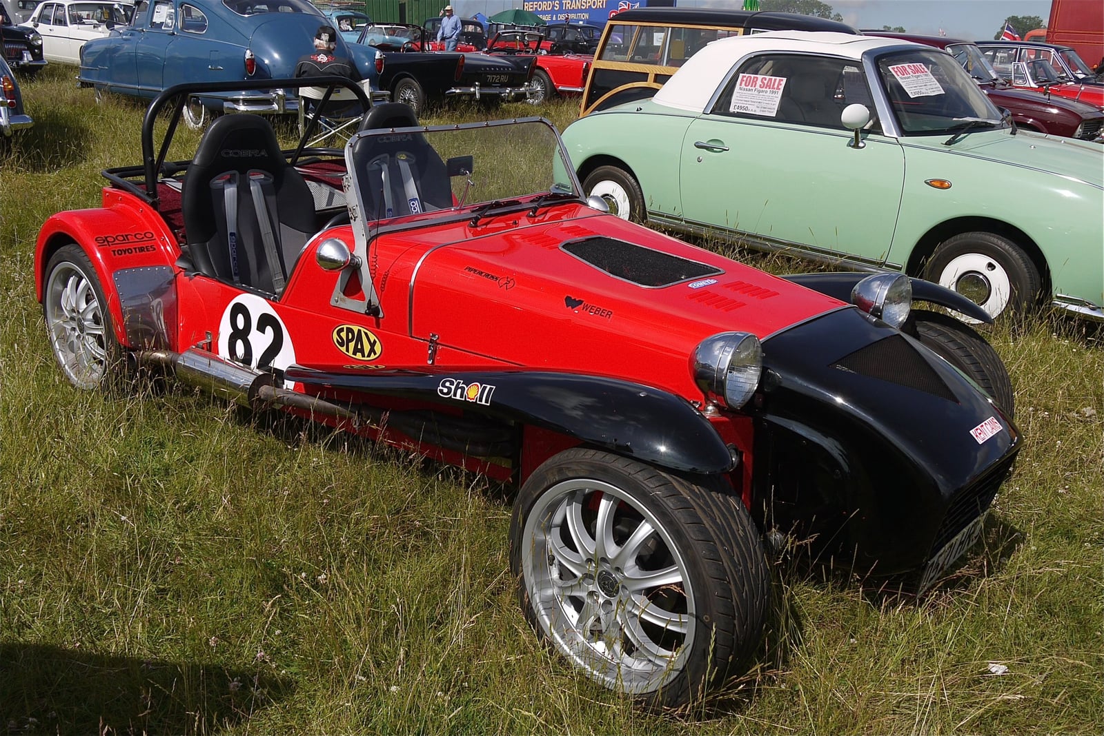 A red Robin Hood Seven-style race car with the number 82 and black wings, front three-quarter view