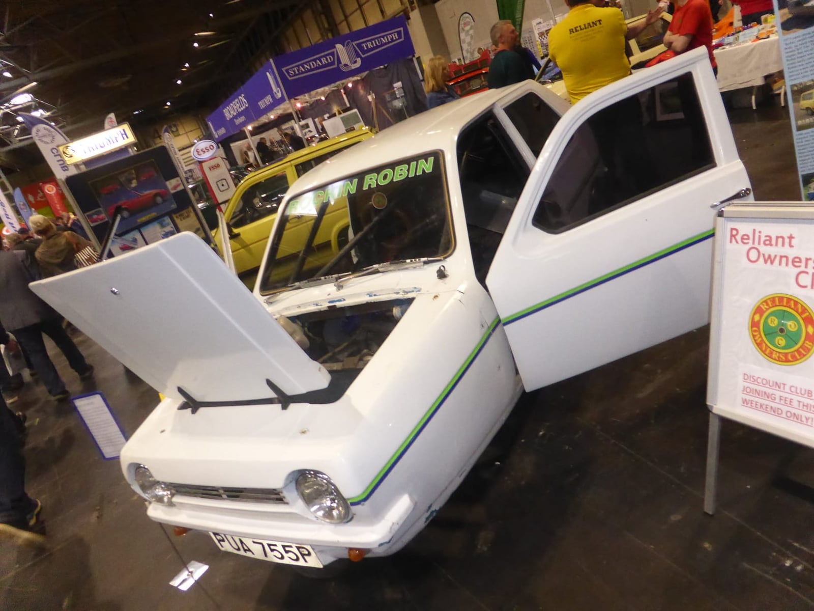 A white Reliant Robin displayed with its doors and bonnet open on a Reliant Owners Club stand
