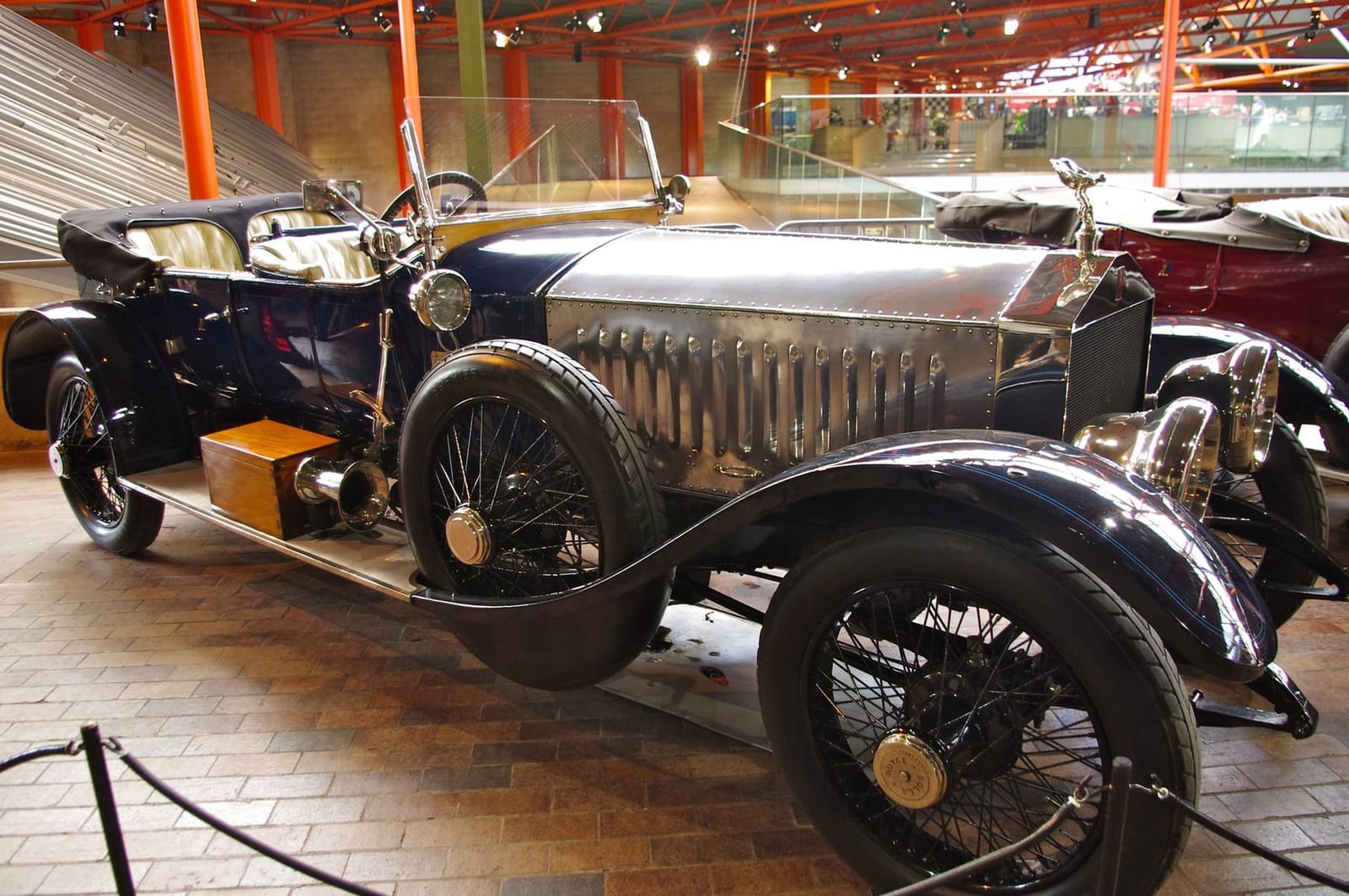 A silver Rolls-Royce Silver Ghost with polished fittings displayed in a museum