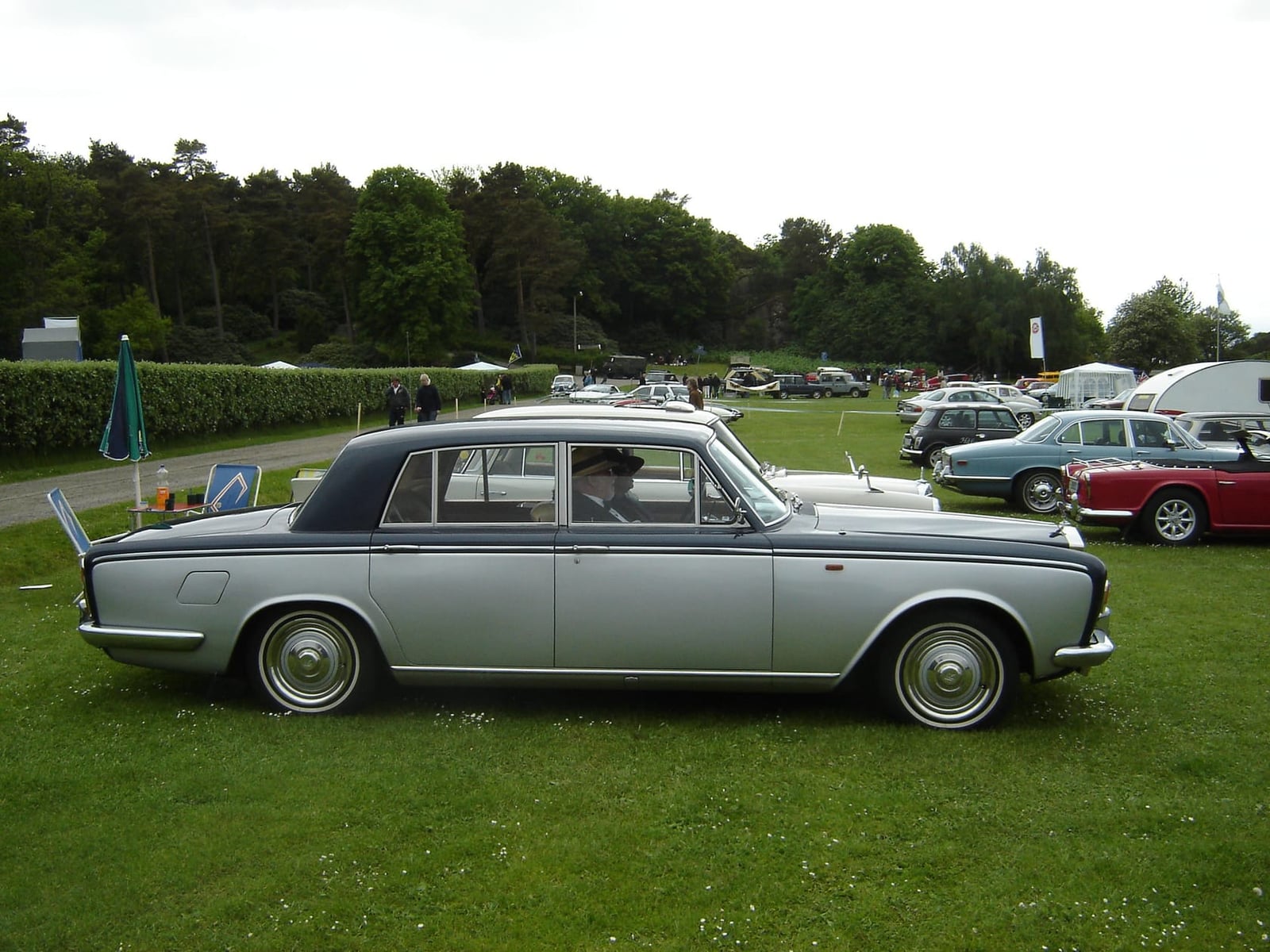A silver Rolls-Royce Silver Shadow in profile on a show field