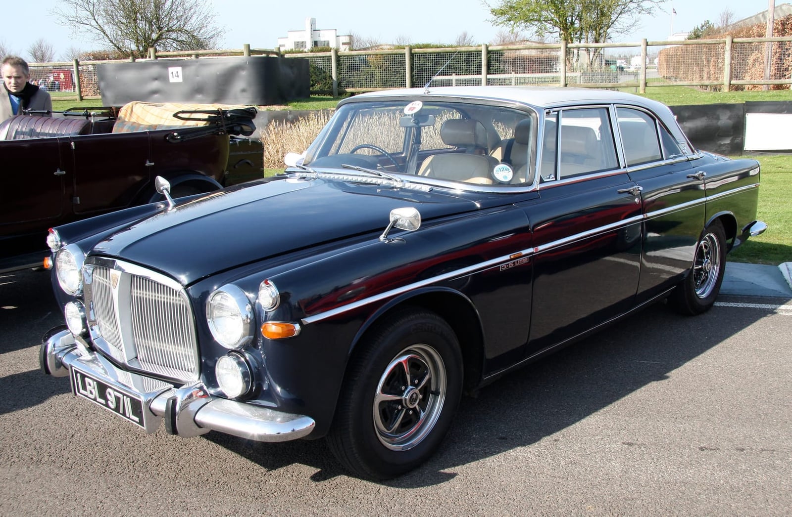 A dark blue Rover P5B 3.5-litre V8 coupe on tarmac at a classic car event, front three-quarter view
