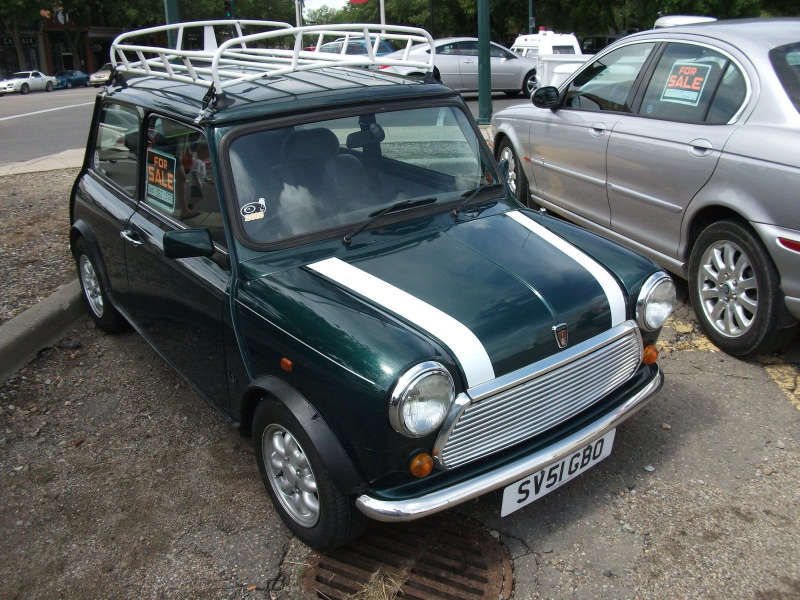 A British Racing Green Rover Mini with white bonnet stripes, front three-quarter view