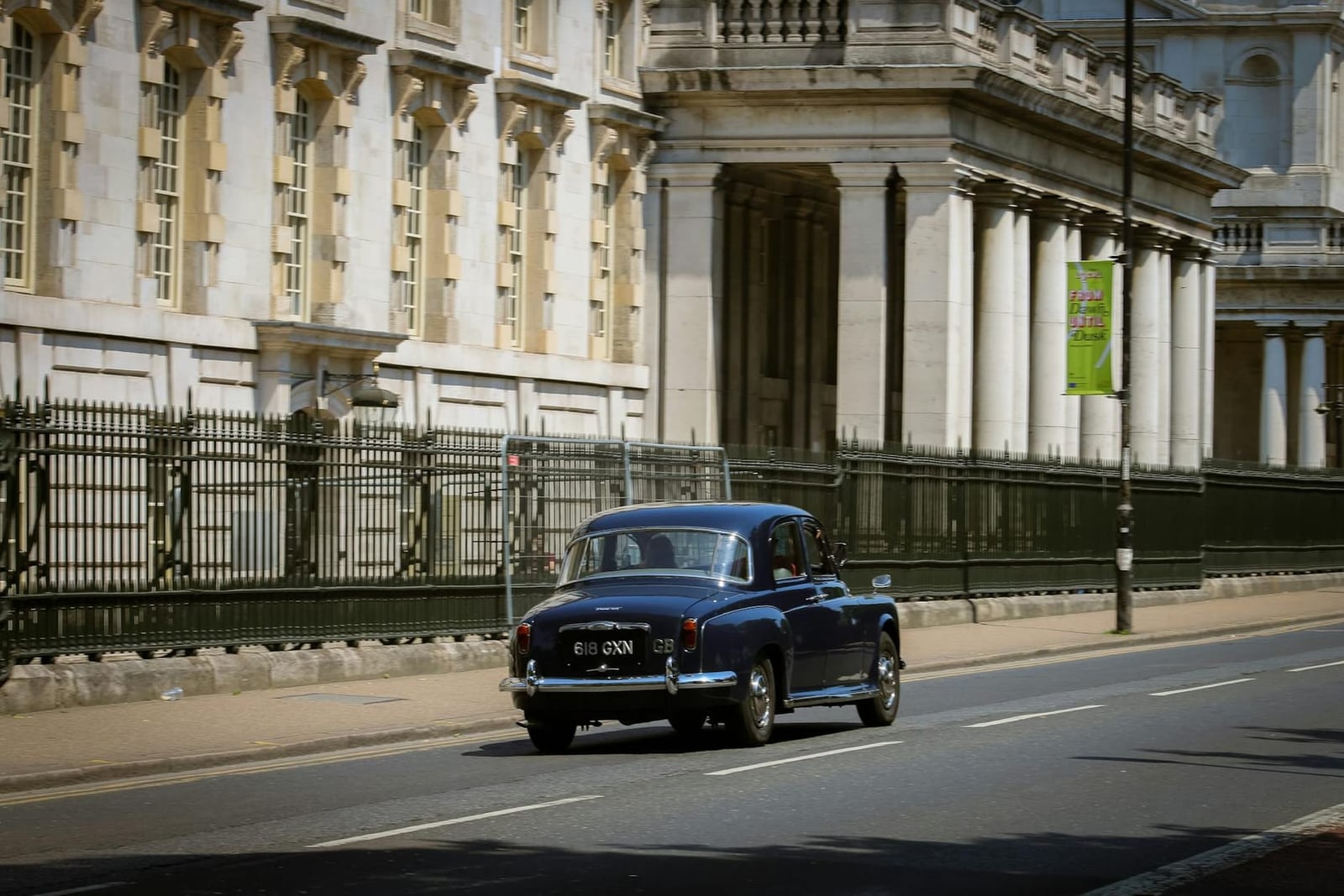 A blue Rover P4 driving on a road, rear three-quarter view
