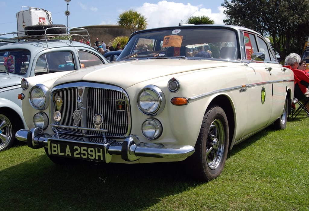 A cream Rover P5B saloon with its full-height roofline on grass at a classic car show, front three-quarter view, UK registration BLA 259H